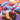 A pile of colourful, retired adult toys on an ombre purple and orange background